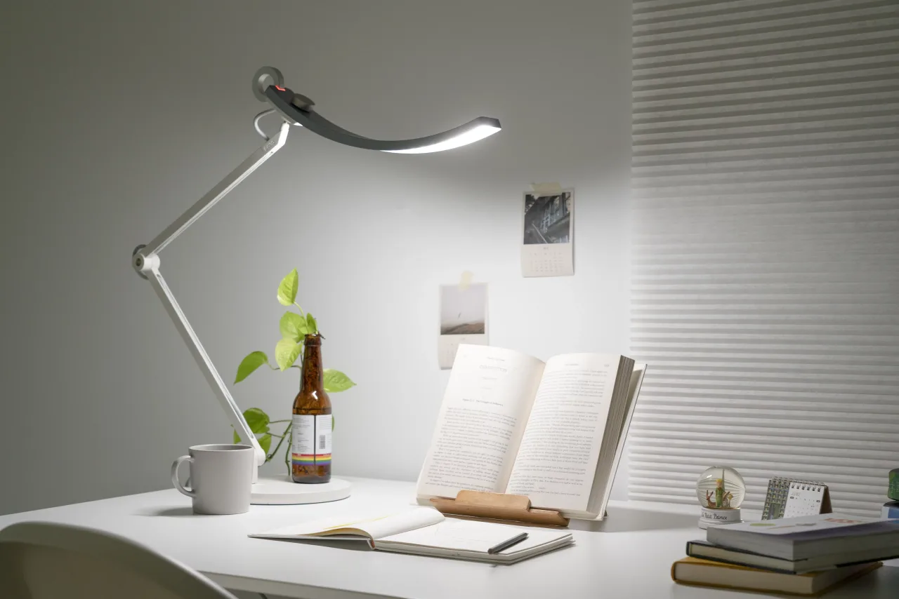 Mesa de estudos iluminada por abajur à noite, em estética lo-fi