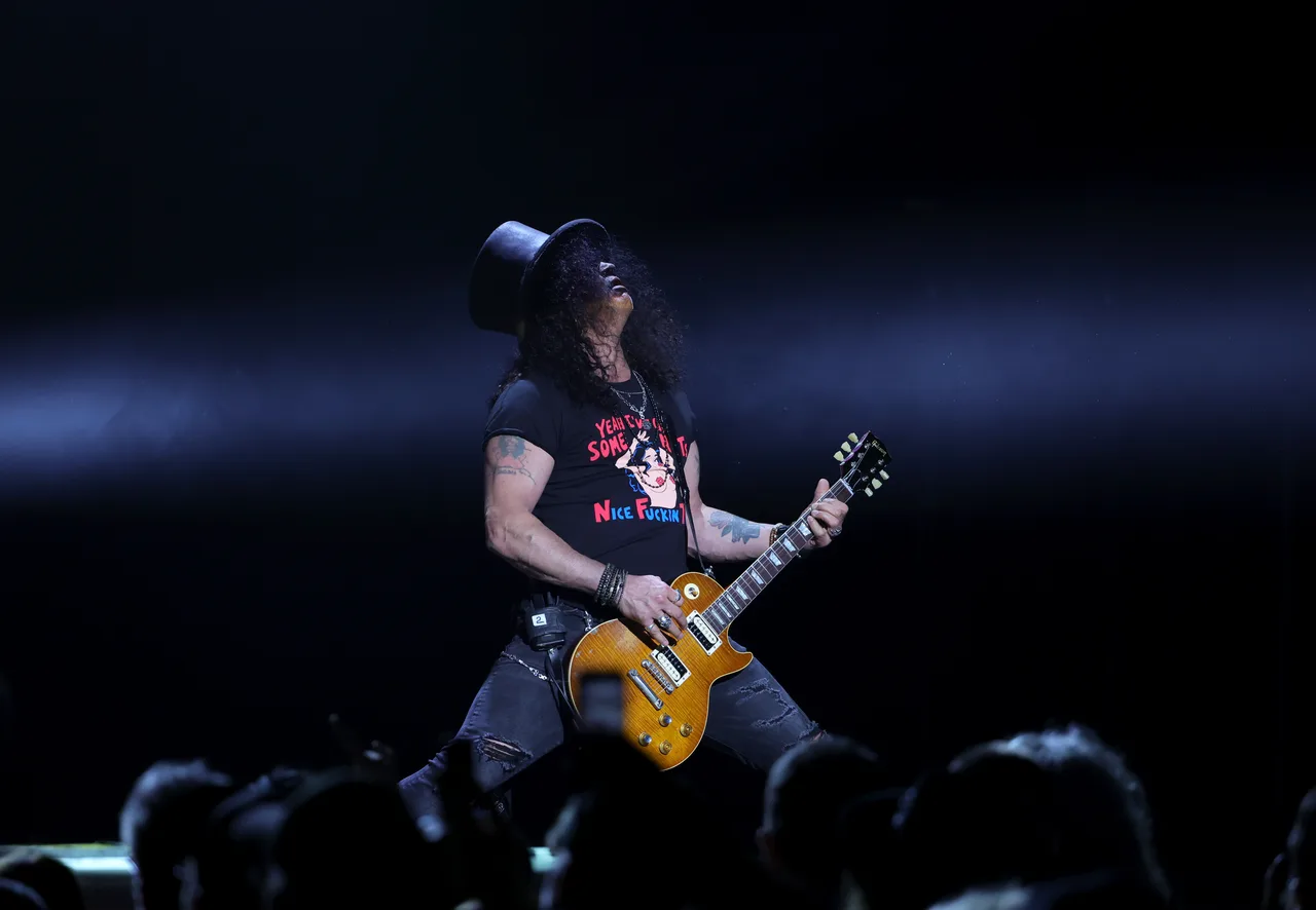 Slash tocando guitarra em show ao vivo